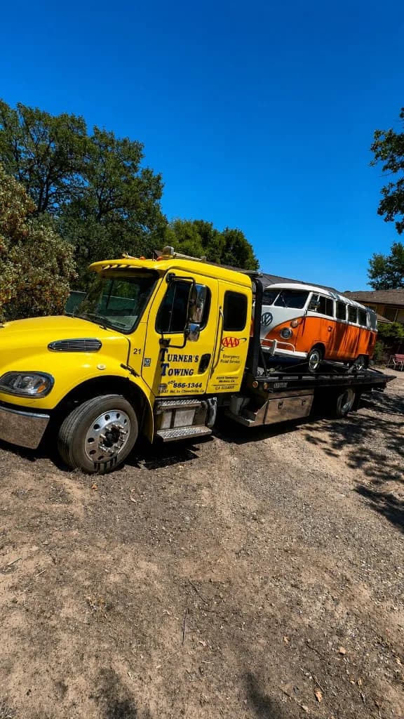 Turner's Towing flatbed truck carefully transporting a classic Volkswagen bus